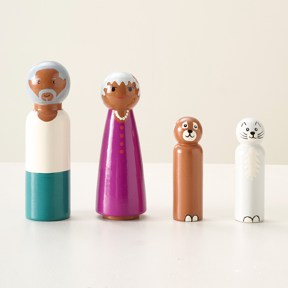 Figurines en bois peint représentant des personnages et des animaux, aux formes arrondies et aux couleurs douces, pour maison de poupée.